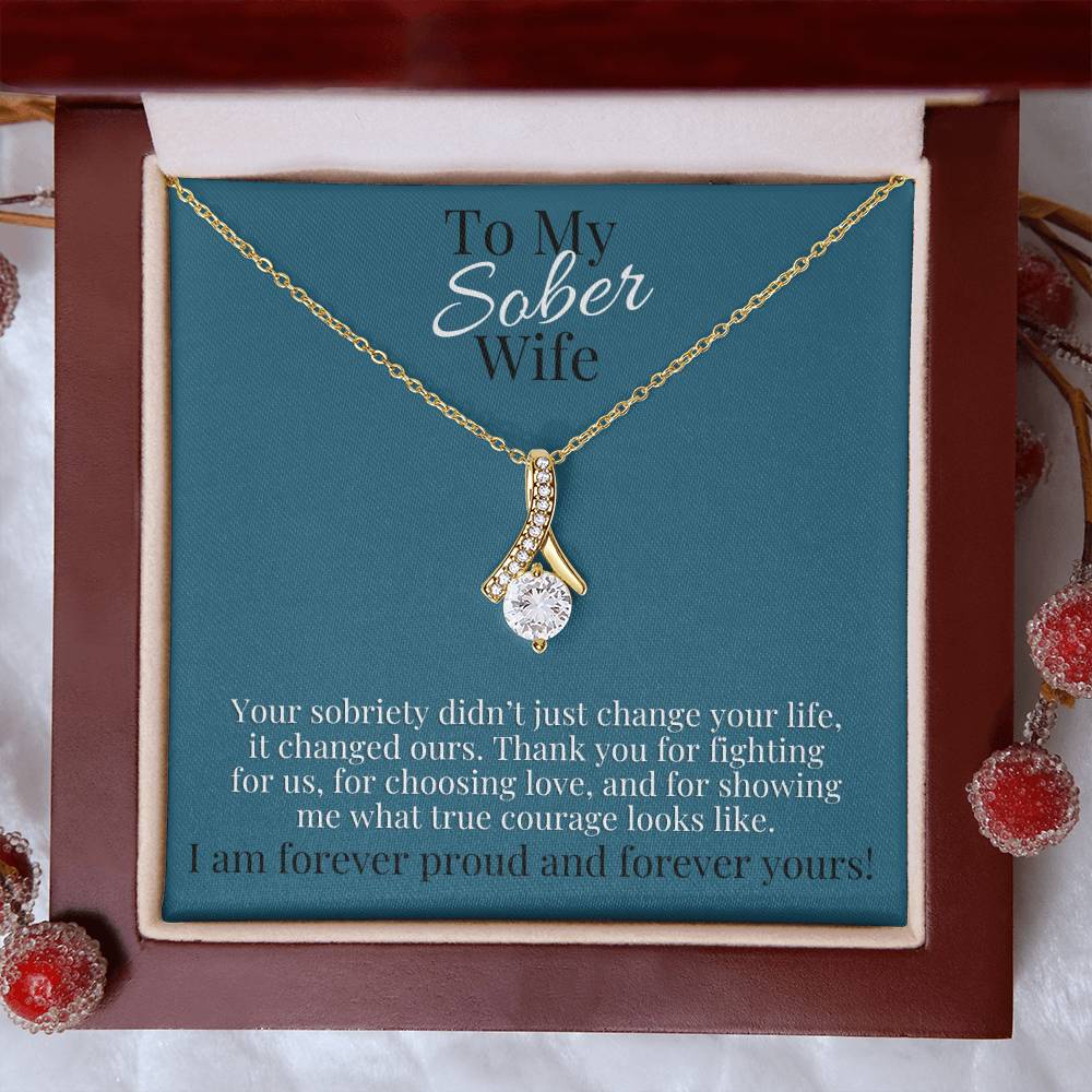 Gold-tone teardrop pendant necklace in red gift box with blue card backing