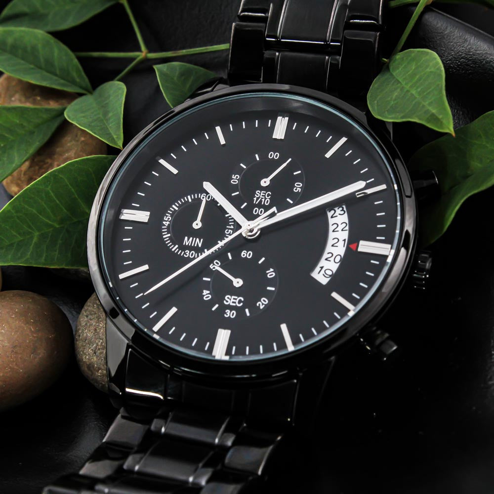 Black chronograph wristwatch with metal link bracelet, close-up of black dial