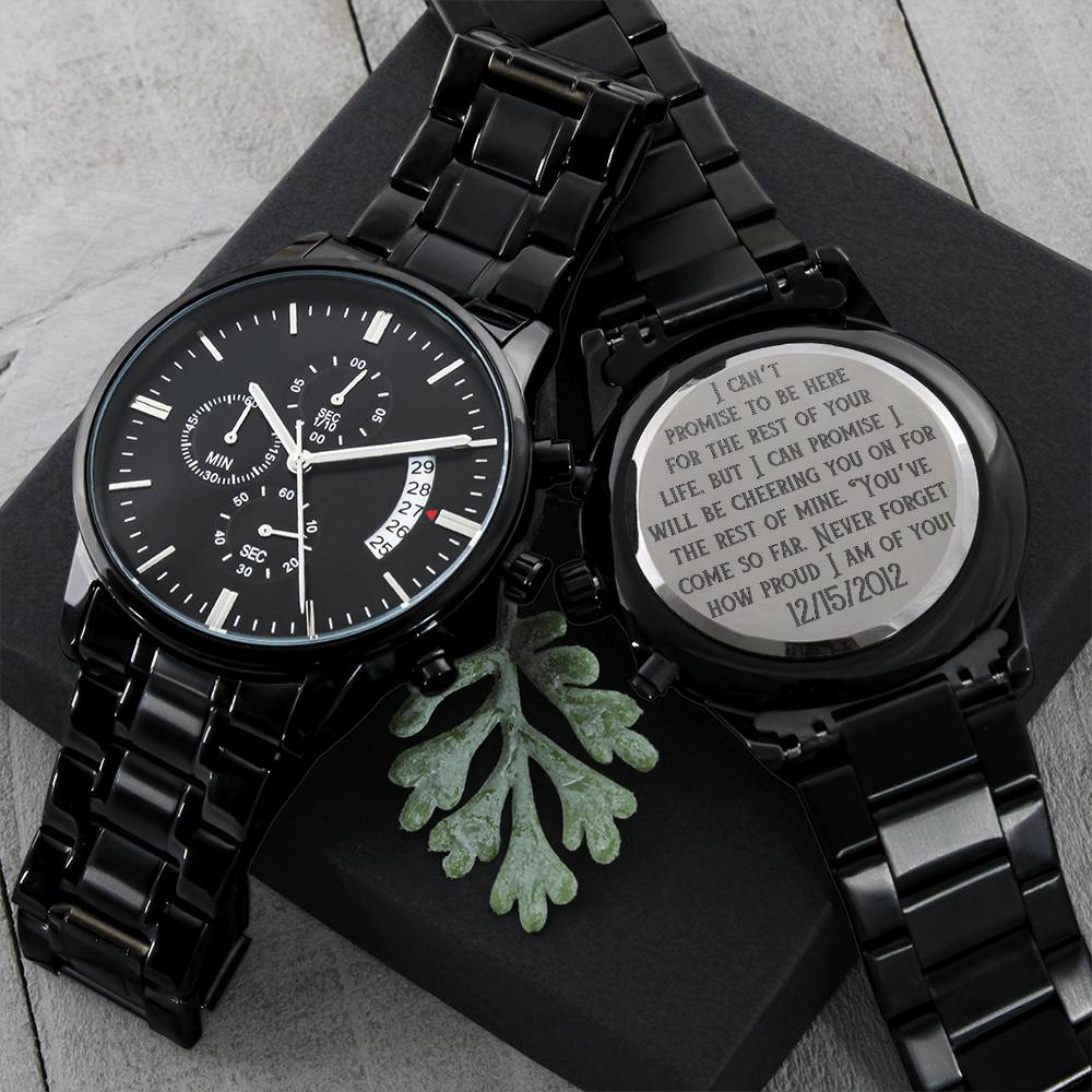 Black metal wristwatch with engraved caseback on dark gift box with leaves