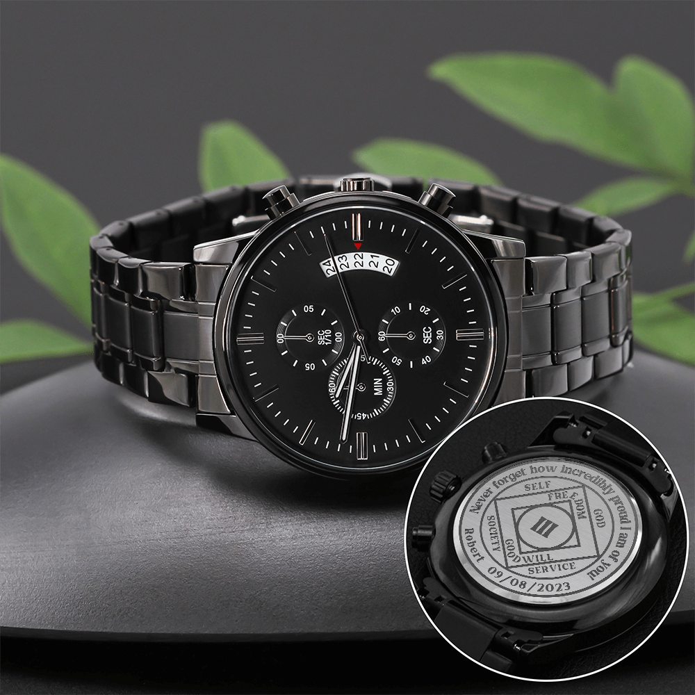 Men's black chronograph wrist watch on a dark surface with engraved caseback