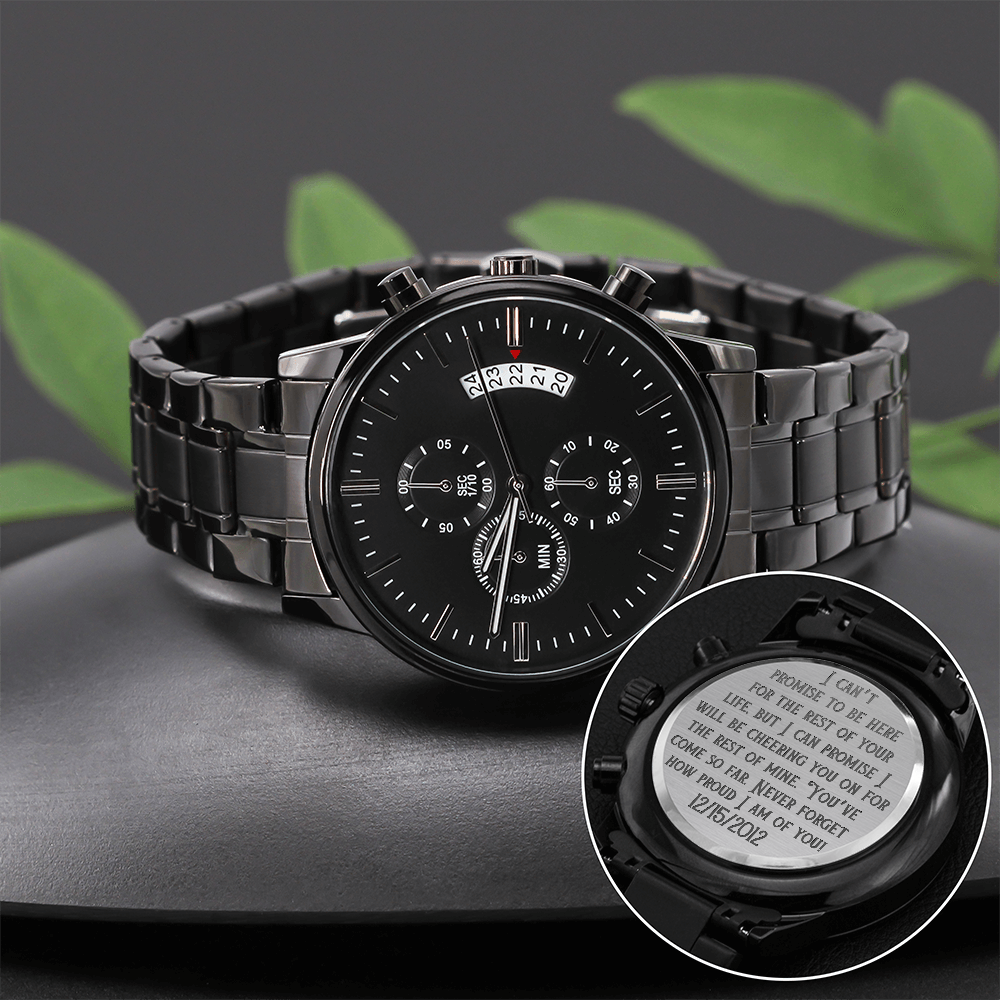 Black metal chronograph wristwatch on a dark surface with engraved caseback