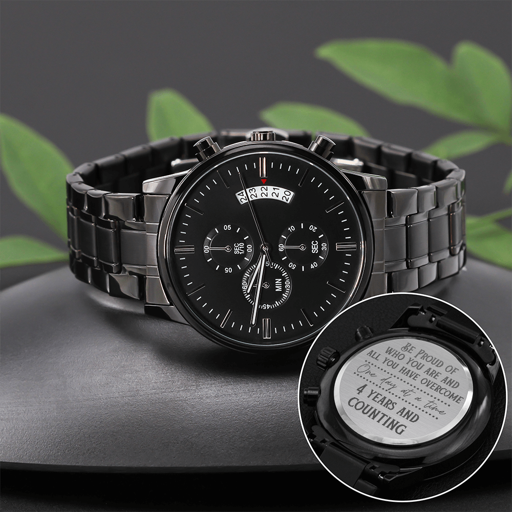 Black chronograph watch with metal bracelet and engraved companion case back