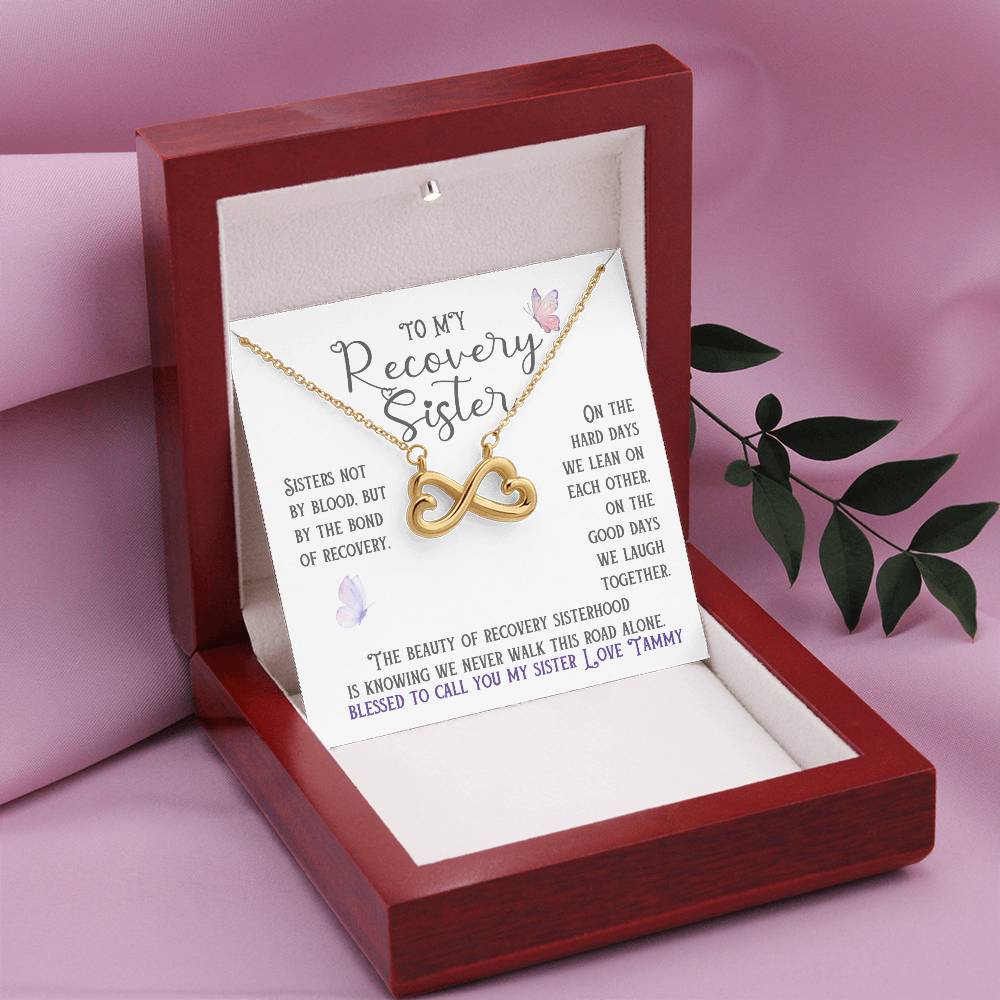 Gold infinity necklace with heart charm in an open gift box