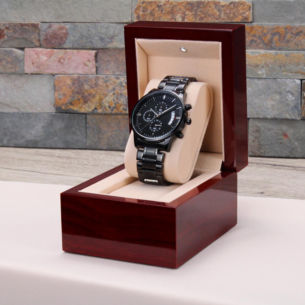 Black wristwatch on beige cushion inside wooden presentation box