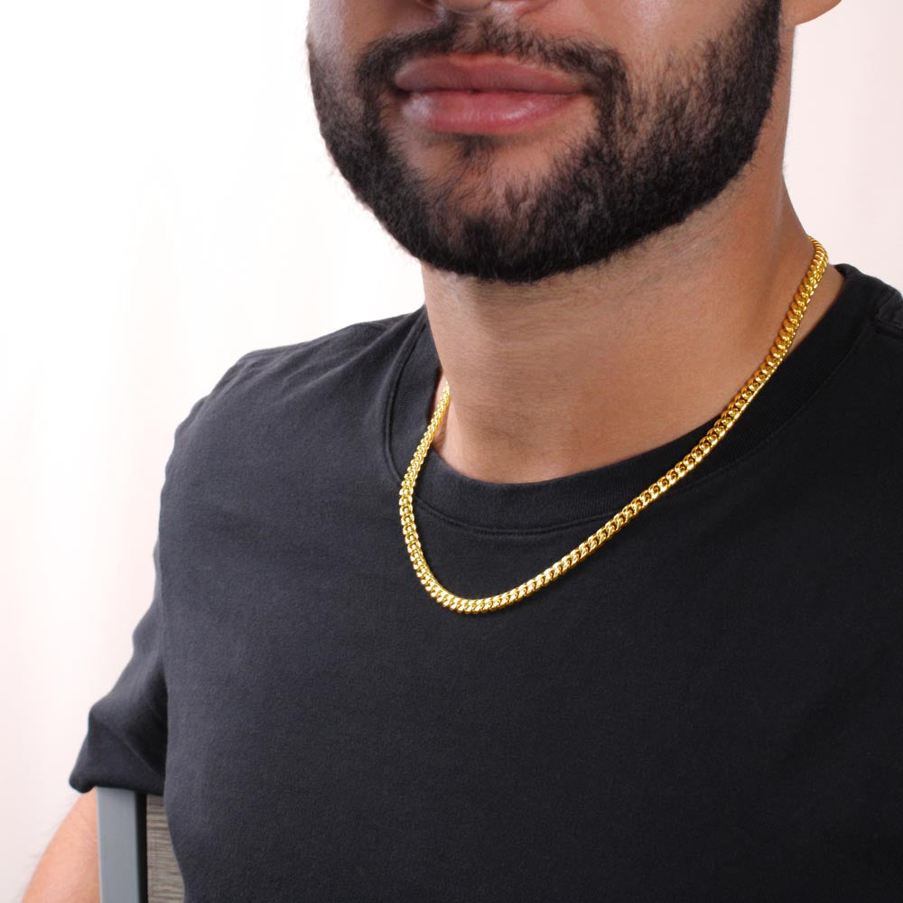 Gold-tone Cuban link chain necklace worn at the collar