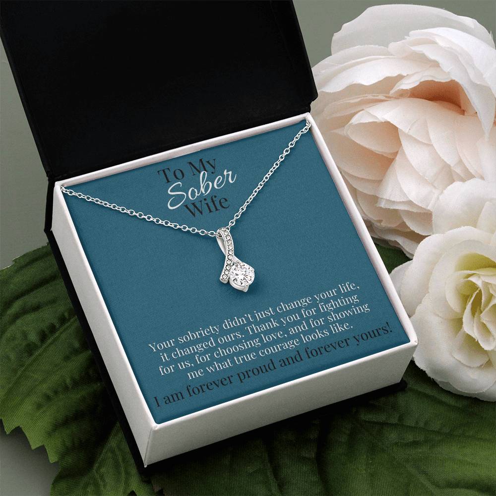 Silver-tone teardrop pendant necklace in open gift box with blue card backing