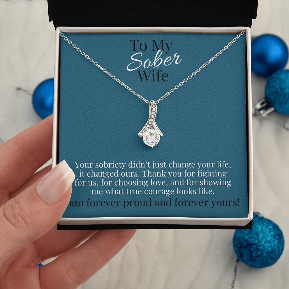 Silver-tone teardrop pendant necklace with small clear stones, shown in gift box