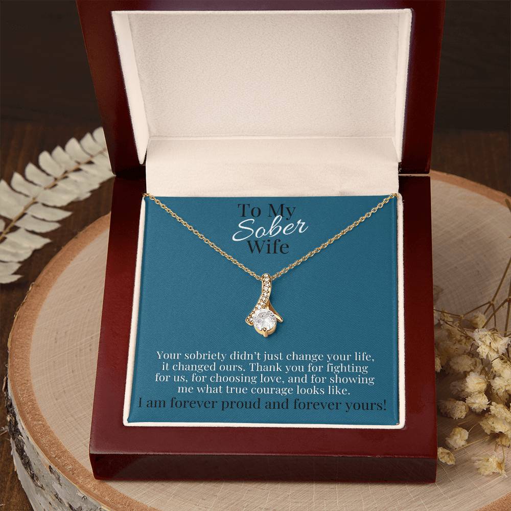 Gold-tone teardrop pendant necklace in closed gift box with blue card insert