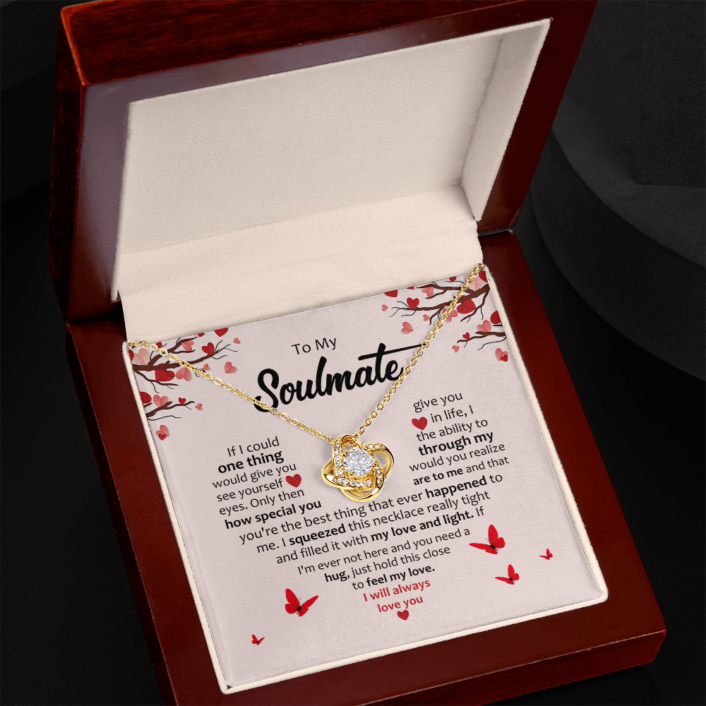 Gold heart knot pendant necklace with round stones on chain in open box