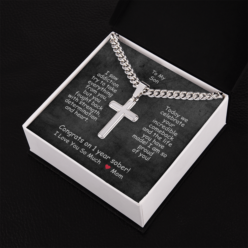 Cross pendant necklace in a white gift box with black lid.