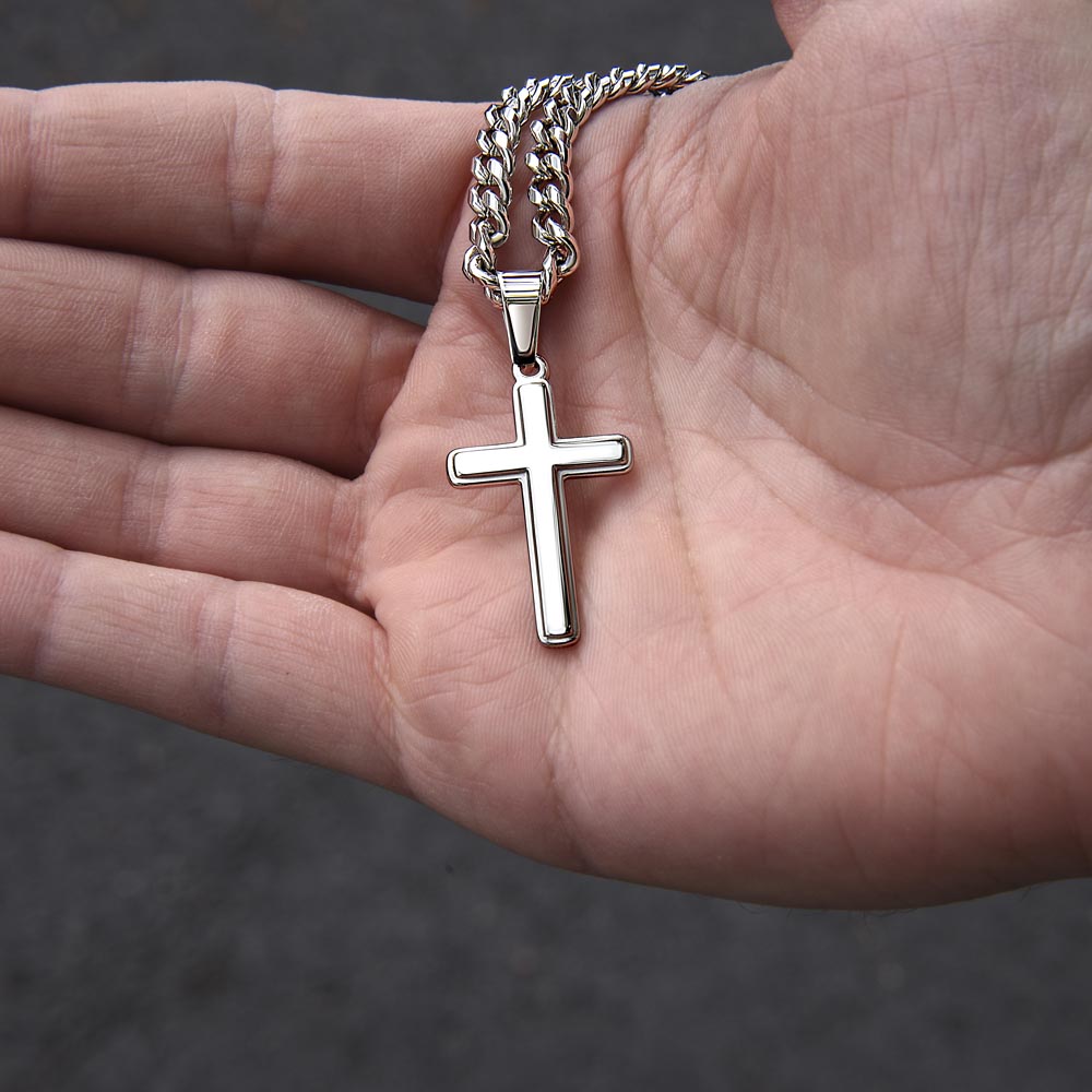Silver cross pendant on chain, shown in open palm