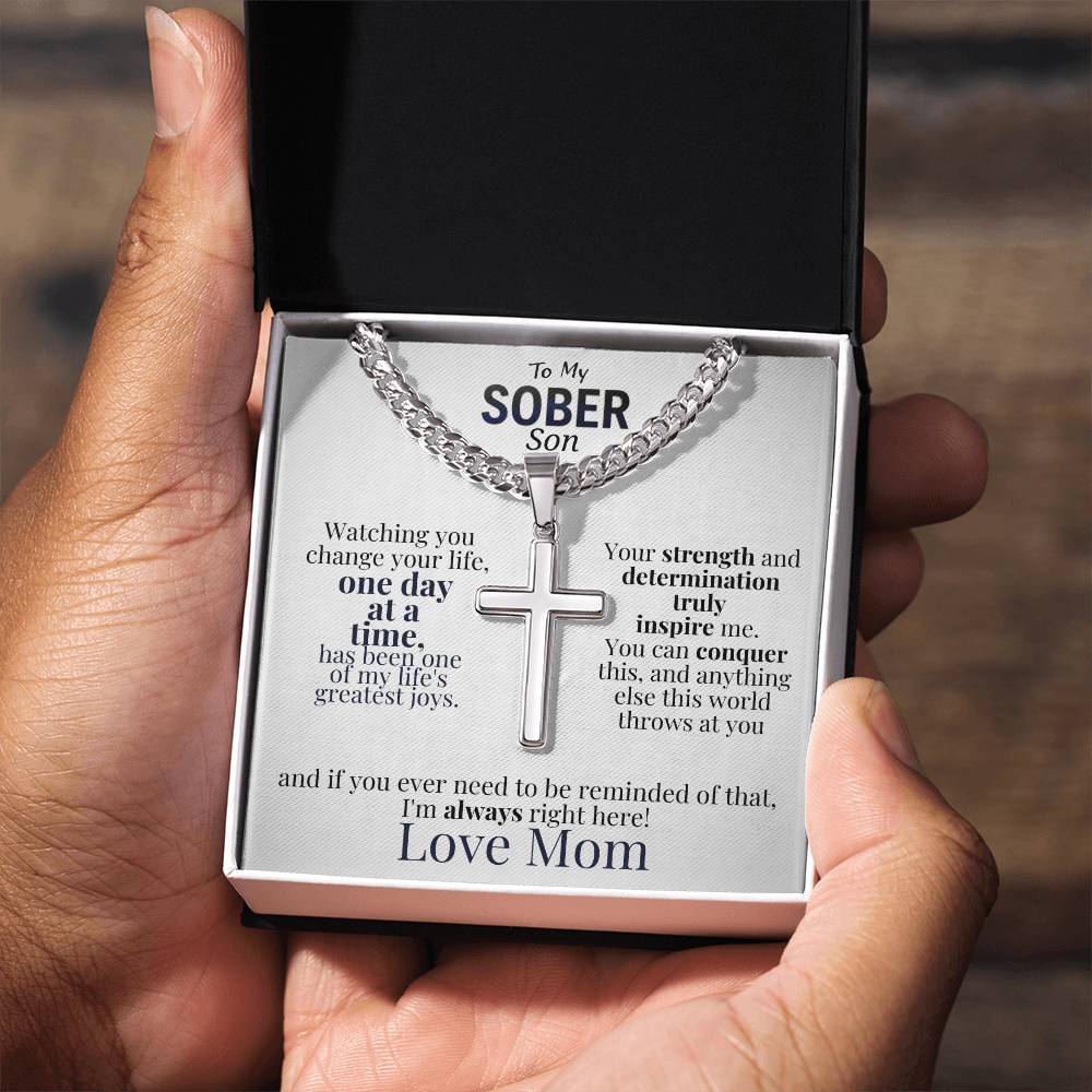 Cross necklace and message card in open box held by hands