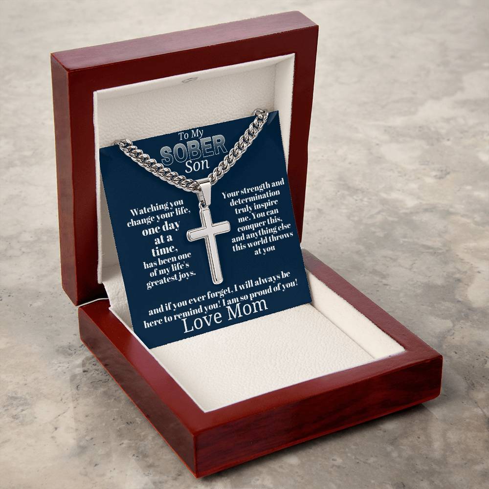 Silver-tone cross pendant necklace on blue card inside open wooden gift box