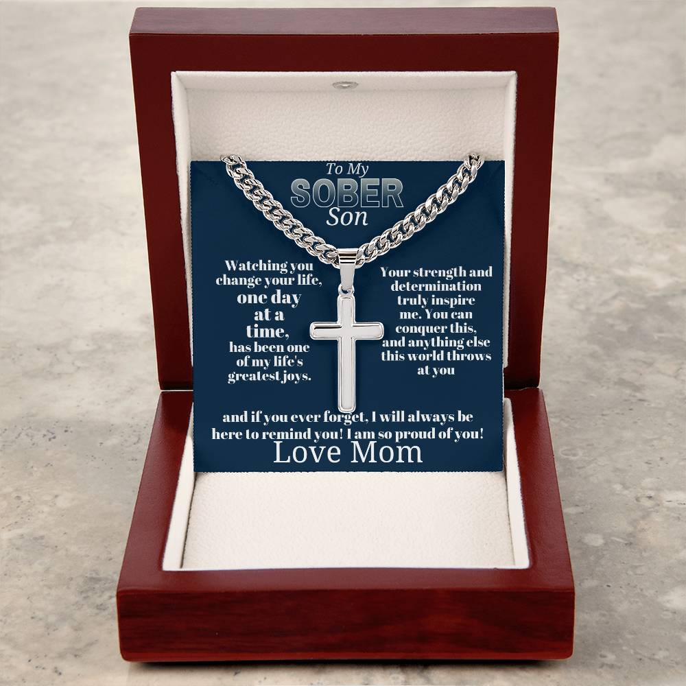 Silver-tone cross pendant necklace on blue card inside open wooden gift box