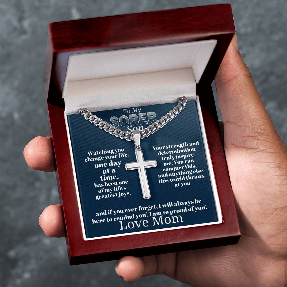 Silver-tone cross pendant necklace in open wooden gift box, close-up view