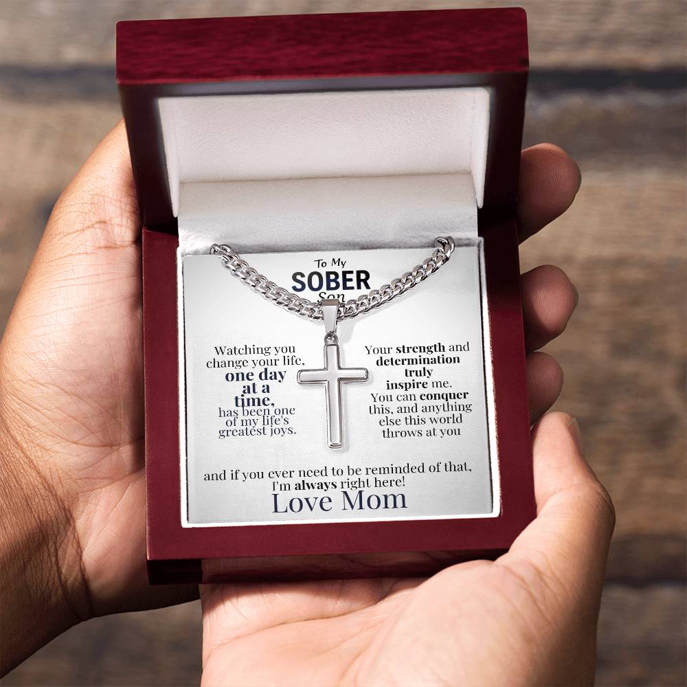 Cross necklace with message card inside red gift box held in hand
