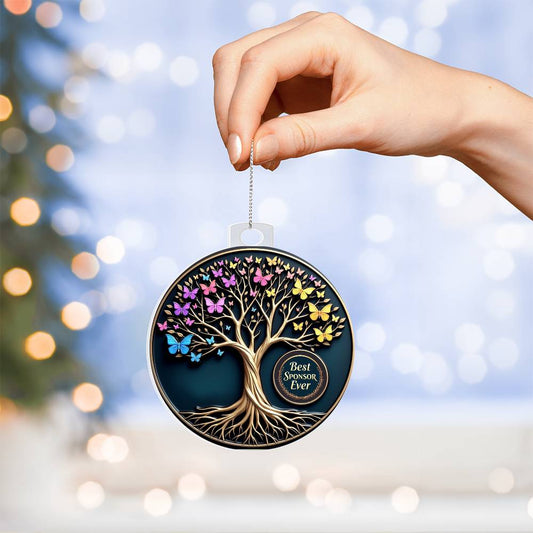 Acrylic tree ornament with colorful butterflies and hanging loop, held by hand