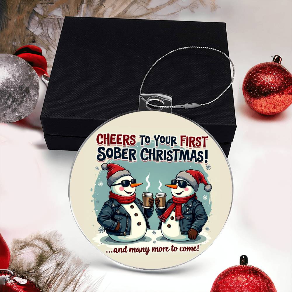 Round Christmas ornament with penguin couple graphic, on black gift box
