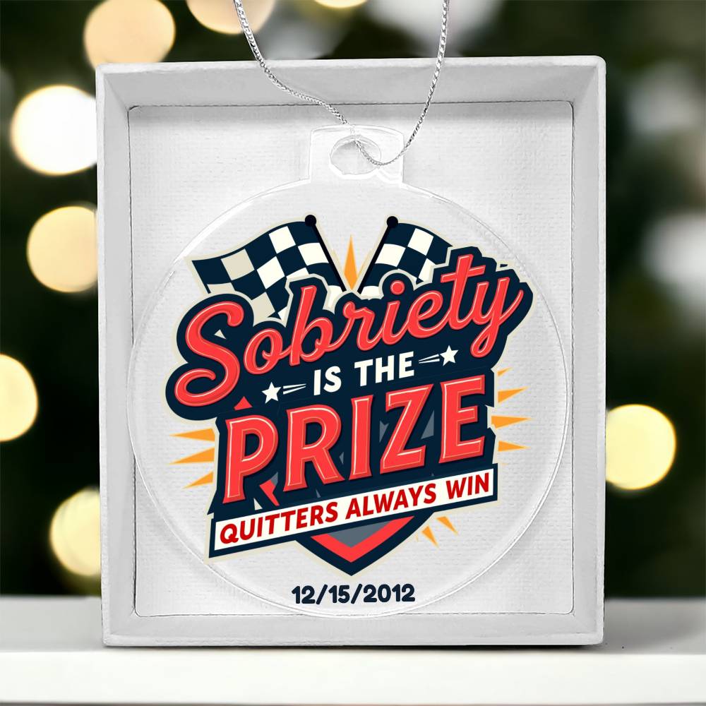 Round hanging ornament labeled “Sobriety Is The Prize” on white gift box packaging
