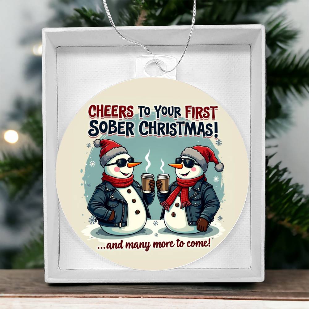Round Christmas ornament with penguin couple graphic, placed in white gift box