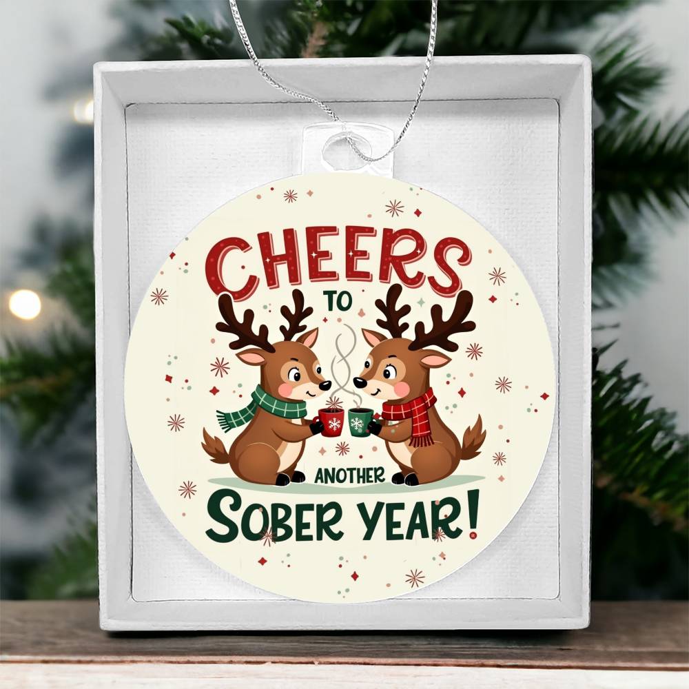Round ornament in white gift box with 'Cheers to Another Sober Year!' reindeer design