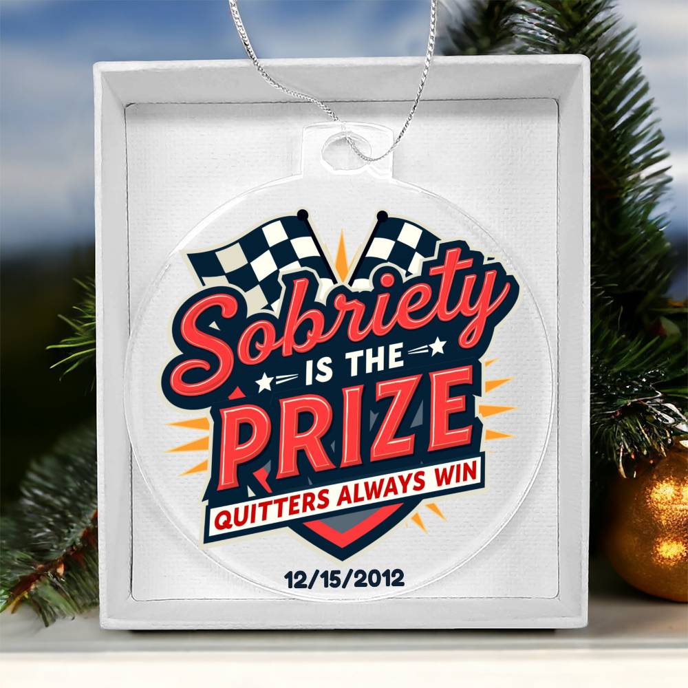 Round hanging ornament on white gift box with “Sobriety Is The Prize” and checkered accents