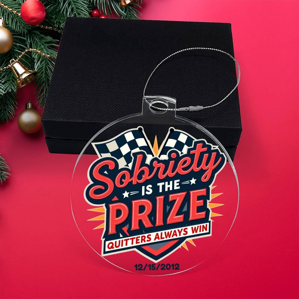 Round hanging ornament on red backdrop with “Sobriety Is The Prize” and “Quitters Always Win”