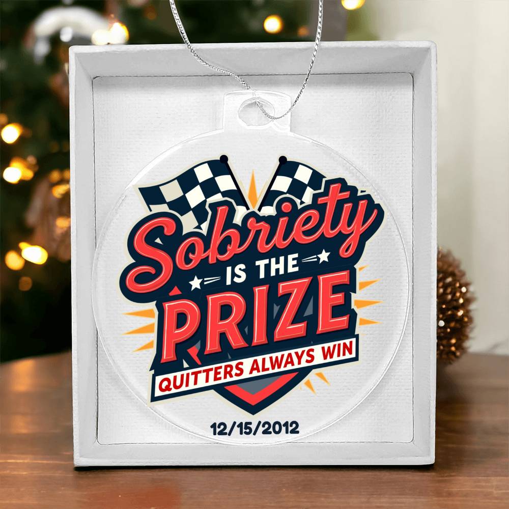 Round hanging ornament on white gift box with “Sobriety Is The Prize” and date marking