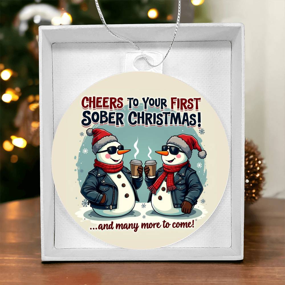 Round Christmas ornament with penguin couple graphic, hanging above white gift box