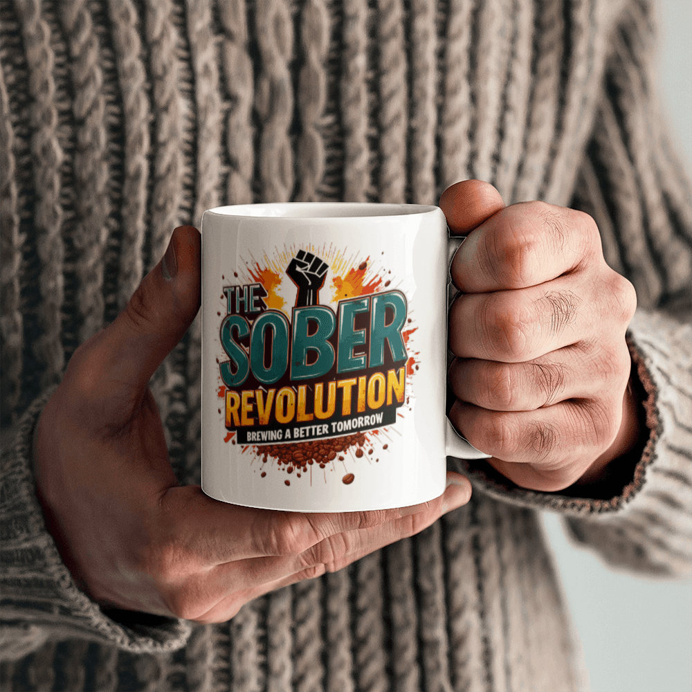 White ceramic mug with 'The Sober Revolution' graphic, held by hands