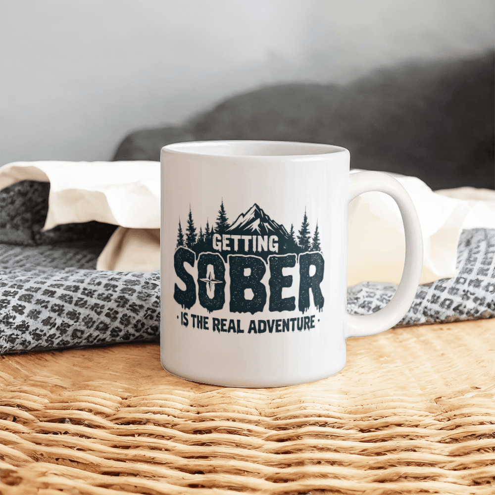 White ceramic mug with black 'GETTING SOBER' and 'is the real adventure' print
