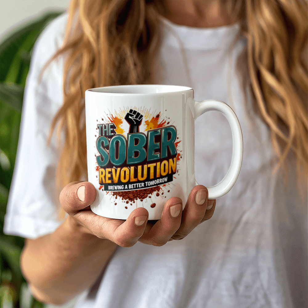 White ceramic mug with 'The Sober Revolution' graphic, held in two hands