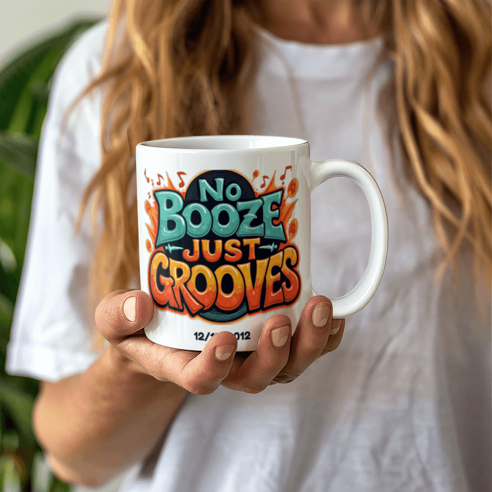 White ceramic mug held in hands with 'No Booze Just Grooves' print and date 12/15/2012