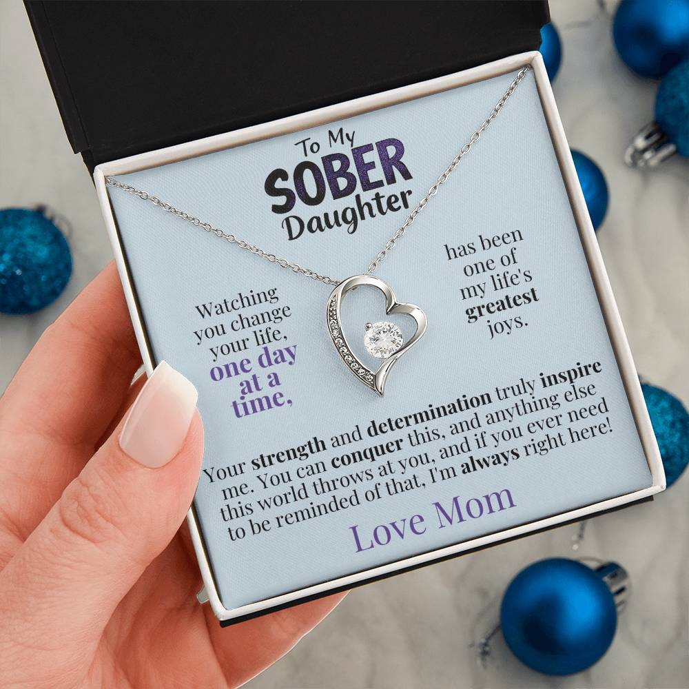 Silver heart pendant necklace on a message card inside an open gift box