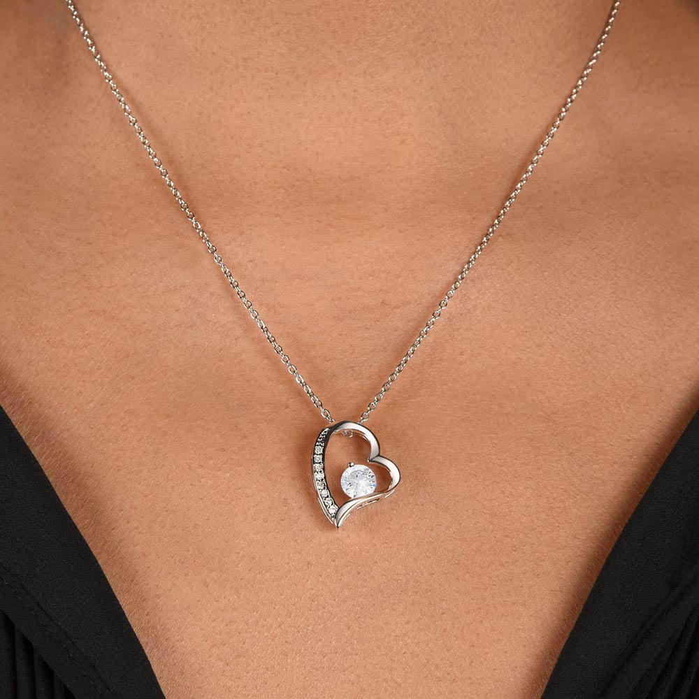 Silver heart pendant necklace close-up on bare skin with fine chain