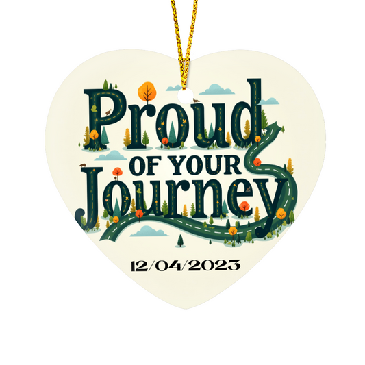 Heart ornament with “Proud of your Journey” and “12/04/2023”, hanging by gold cord.