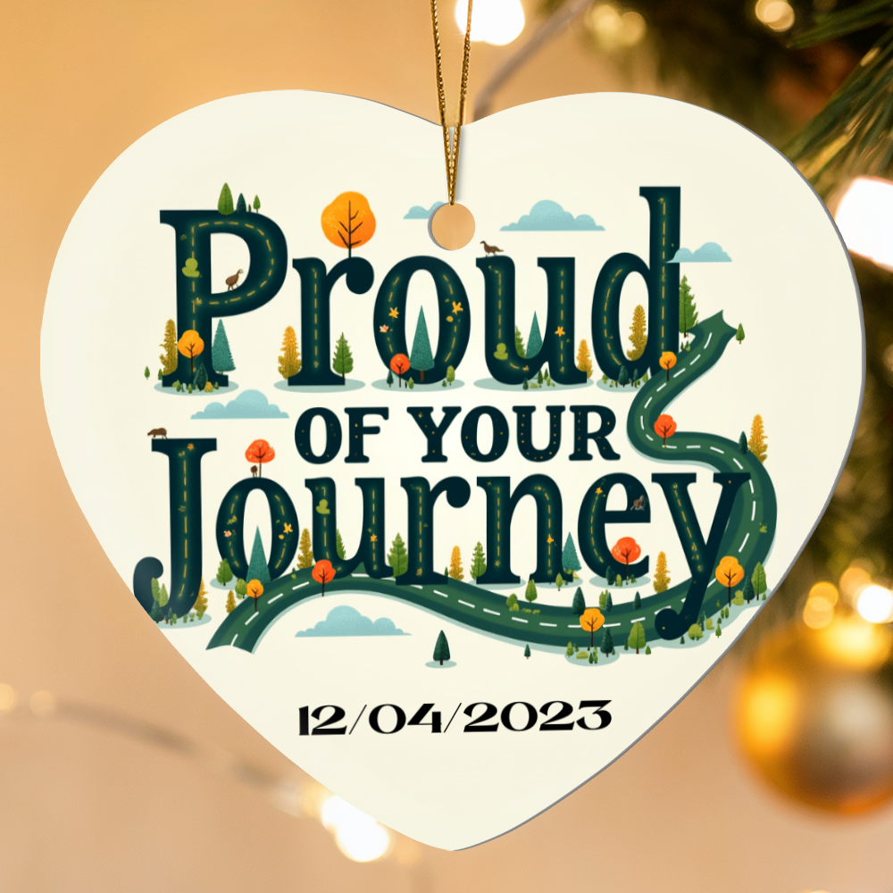 Heart ornament with “Proud of your Journey” and “12/04/2023”, suspended by gold cord.