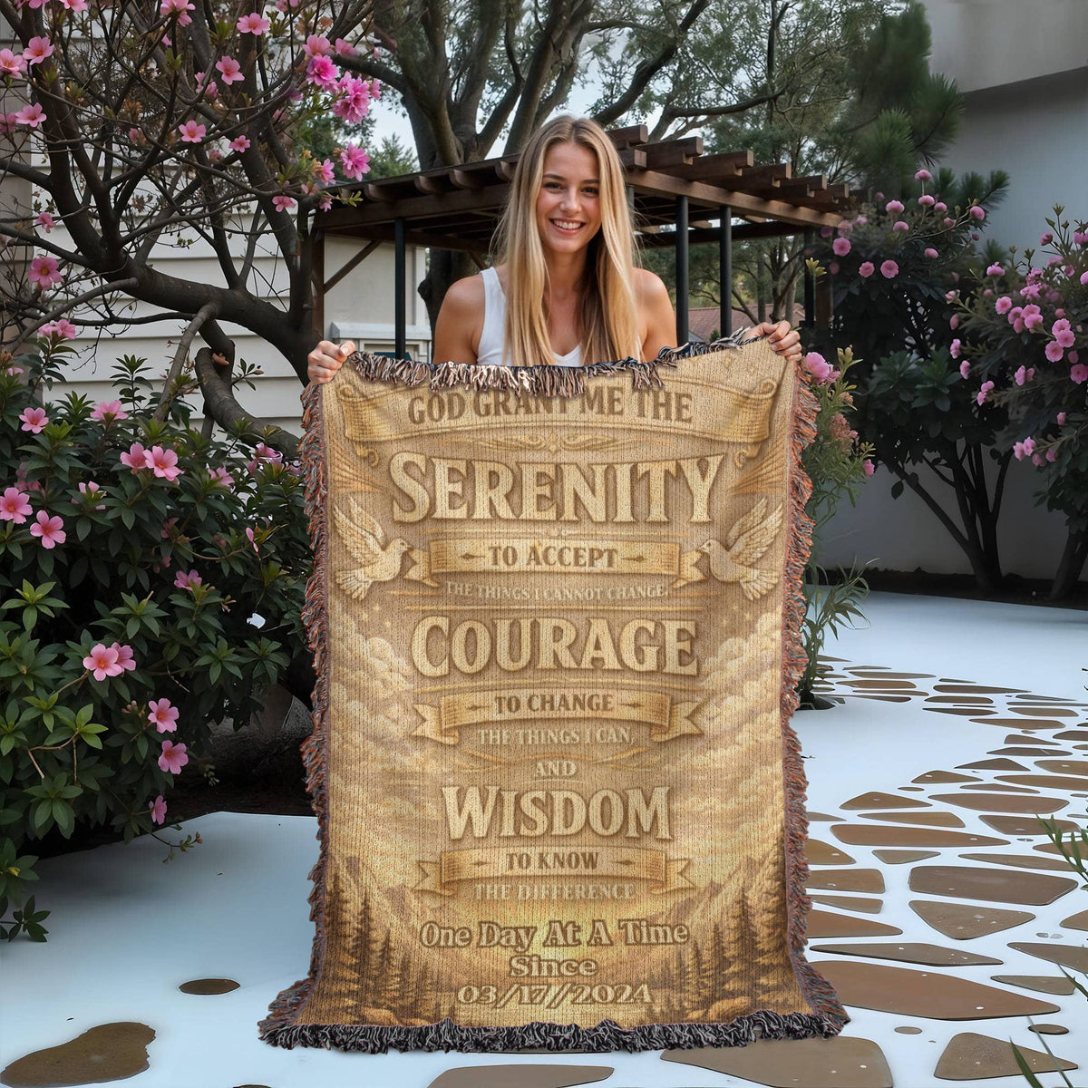 Beige woven blanket held up, showing Serenity Prayer words in stacked bands