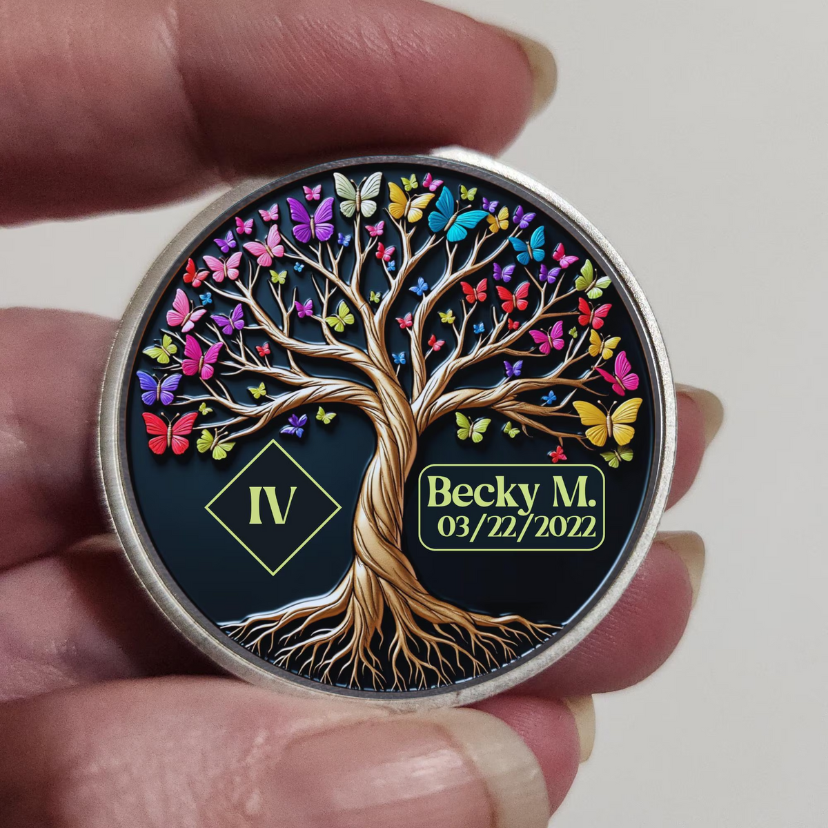 Round recovery coin held in hand with Tree of Life artwork and date label