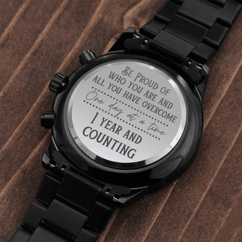 Black chronograph watch engraved case back on black metal bracelet